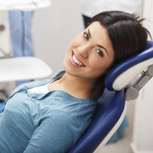 Smiling woman leaning back in dental chair