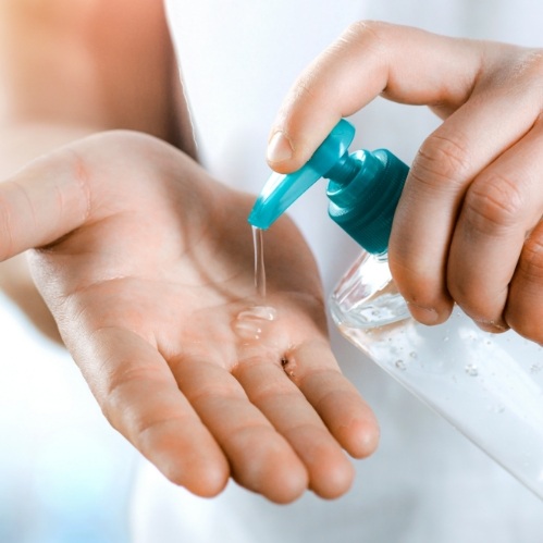Person squeezing hand sanitizer into their hand