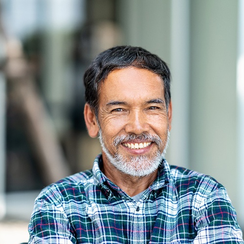 Dentist holding a set of dentures in Carrollton