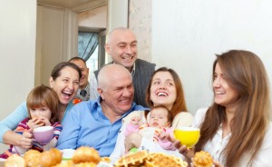 Three generations of smiling family at dinner table