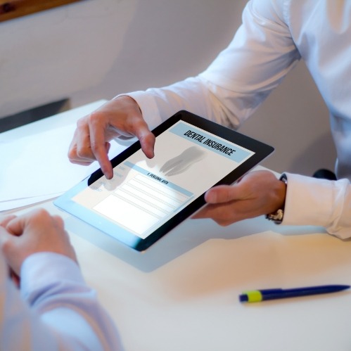 Two people looking at dental insurance information on tablet