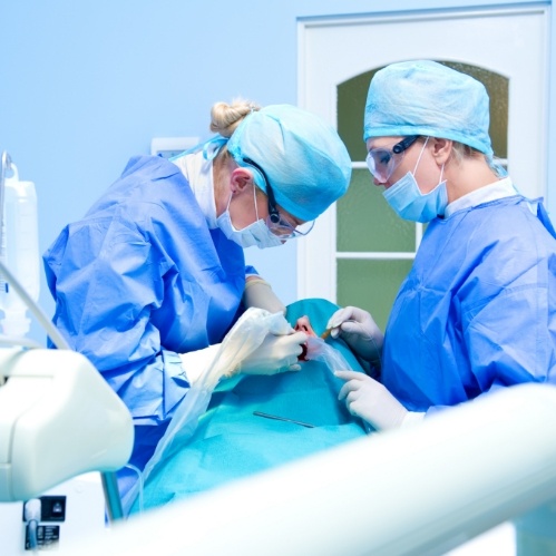 Two dental professionals performing oral surgery in Carrollton