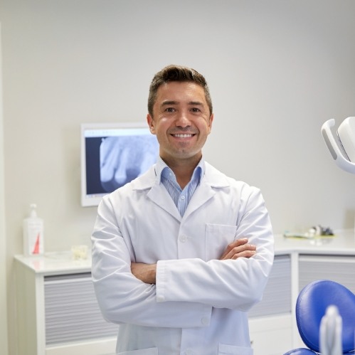 Smiling dentist in white lab coat
