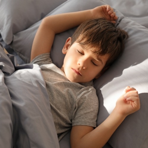 Young boy sleeping on his back