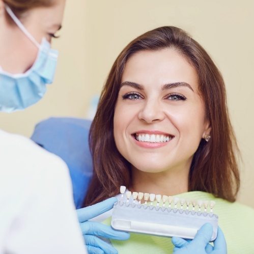 Woman grinning in dental chair at veneers appointment